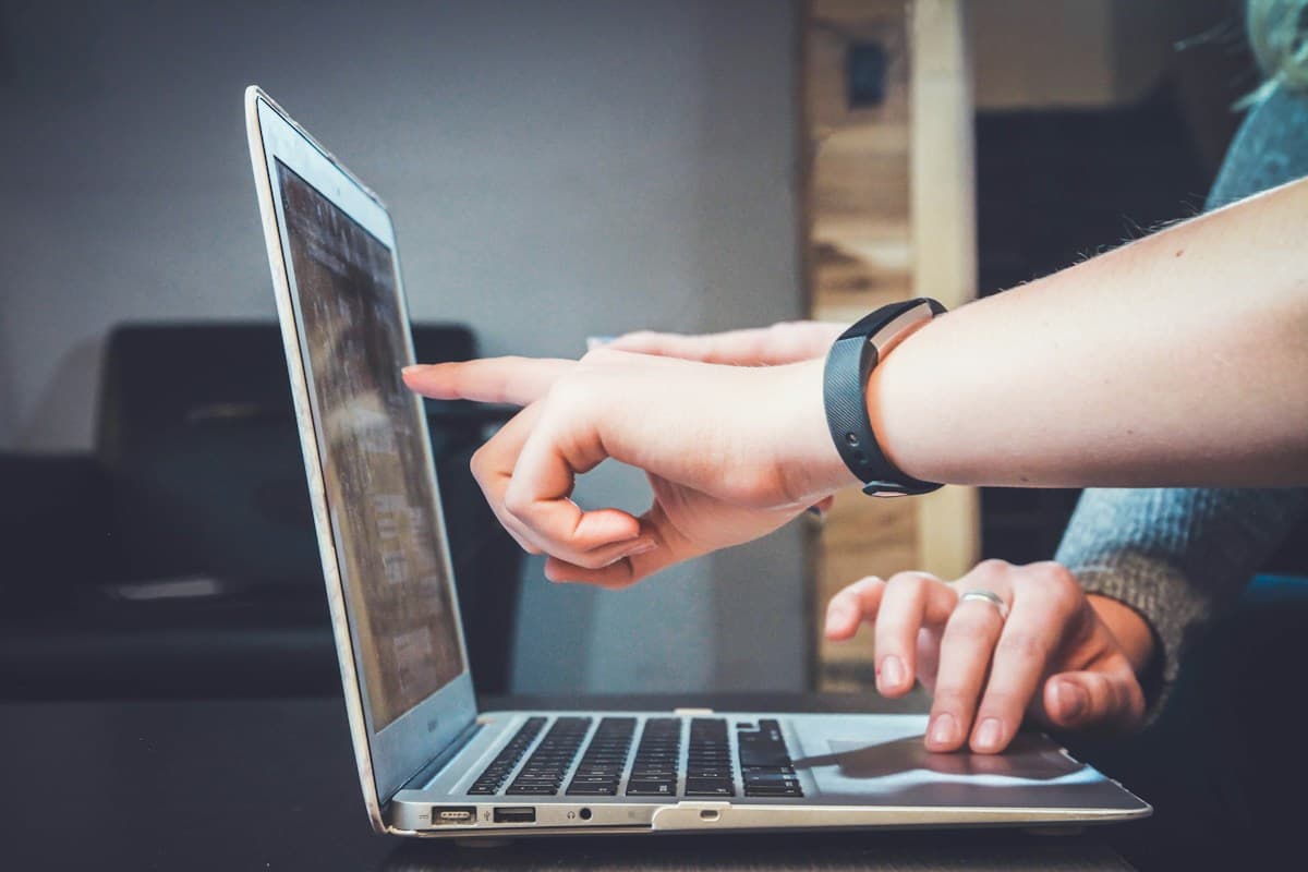 One person guiding another through work on a laptop